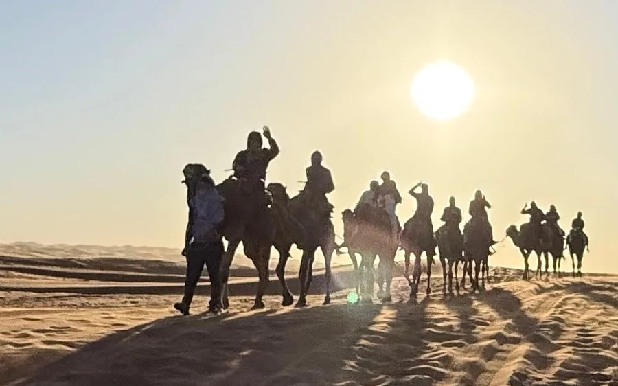 Ein weiter Blick über die Sahara-Dünen mit einem kleinen Zeltcamp in der Ferne