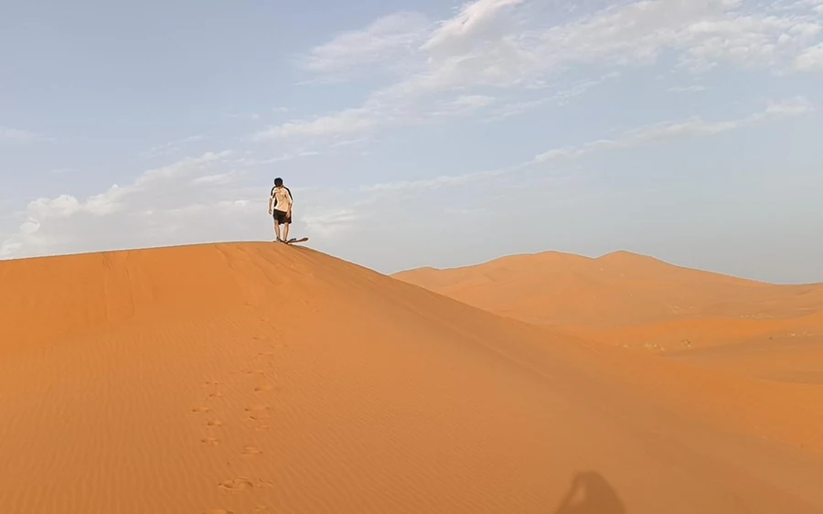 Ein einzelnes Zelt in einem Wüstencamp mit Laternen und Teppichen im Sand